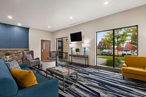 a living room with a blue couch and a tv at Comfort Suites Hudson I-94 in Hudson