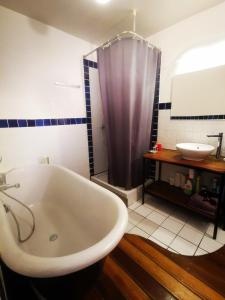 a bathroom with a bath tub and a sink at Trentemoult : Charmante grande maison avec vue sur Loire 105 m2 in Rezé +11 photos