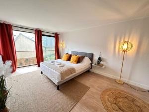 Un dormitorio con una cama y una ventana grande. en Drouet d'Erlon duplex spacieux, terrasse au centre, en Reims