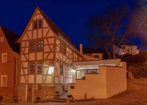 una casa vieja con un edificio por la noche en Wohnen im Denkmal, en Niederbrechen