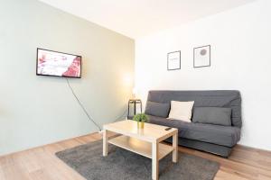 a living room with a couch and a table at Fully-equipped apartment near the center of Lille in Lille