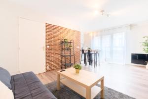 - un salon avec un mur en briques et une table dans l'établissement Fully-equipped apartment near the center of Lille, à Lille
