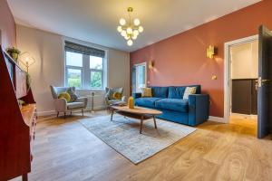 a living room with a blue couch and a table at Haworth Heights - An AMAZING Aparthotel! in Haworth