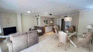 un salon avec un canapé, une table et des chaises dans l'établissement Precioso apartamento en la playa de Jávea By El Conserje, à Jávea