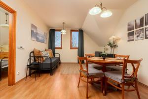 a dining room and living room with a table and chairs at Thermal Valley Apartman - Batthyány Villapark in Zalacsány