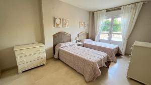 une chambre avec deux lits et une fenêtre dans l'établissement Precioso apartamento en la playa de Jávea By El Conserje, à Jávea