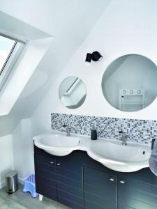 La salle de bains est pourvue d'un lavabo et d'un miroir. dans l'établissement Maison 3* sur la Côte de Granit Rose, à Trégastel