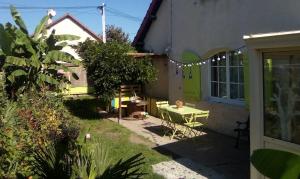 a small garden with a table in the side of a house at Maison proche de la Loire Fourchambault in Fourchambault