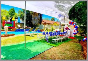 a group of tables and chairs under a tent next to a pool at Horizon Garden Party & Events Venue in Randfontein
