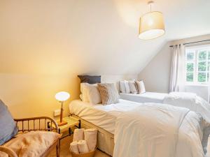 斯托克羅奇福德的住宿－2 Bed in Stoke Rochford 93039，一间卧室配有两张床和椅子