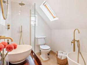 a bathroom with a sink and a toilet and a tub at 2 Bed in Stoke Rochford 93039 in Stoke Rochford