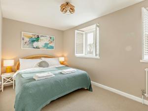 a bedroom with a bed with two towels on it at 2 Bed in Burton Bradstock 93076 in Burton Bradstock