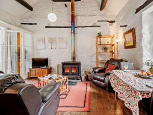Elle comprend un salon doté d'un mobilier en cuir et d'une cheminée. dans l'établissement 1 Bed in Machynlleth 93081, à Cemmaes