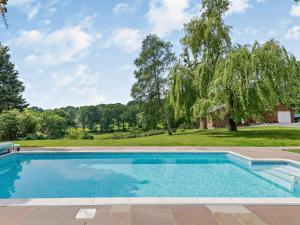 a swimming pool in front of a yard with trees at 5 Bed in Bransgore 91304 in Bransgore