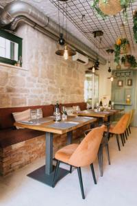 ein Restaurant mit Holztischen und -stühlen und Ziegelwand in der Unterkunft Mak Luxury Rooms in Split