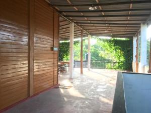 an outdoor patio with a wooden wall and a table at Surf Corner in Matara
