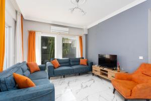 uma sala de estar com sofás azuis e cadeiras laranja em Villa Mazoya em Dalyan