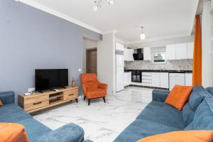 uma sala de estar com um sofá azul e uma televisão em Villa Mazoya em Dalyan