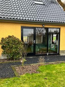 a yellow house with glass doors and a patio at De Danser 2 in Klaaswaal