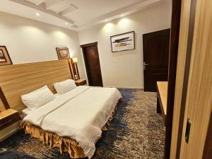 a bedroom with a large bed in a room at قصر البسمة للشقق المخدومةSMILE Serviced Apartments in Jeddah
