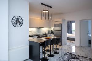 une cuisine avec un îlot et des tabourets de bar dans l'établissement Theotokopoulos Park Renovated Apartment, à Héraklion