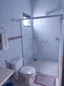 uma casa de banho branca com um WC e um chuveiro em Chalé da Selma I (Isaías) em Alto Paraíso de Goiás