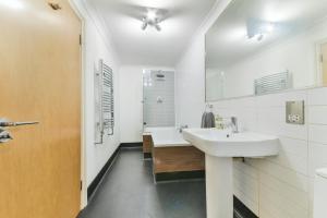 a white bathroom with a sink and a shower at Fantastic Central Line City-pad! in London