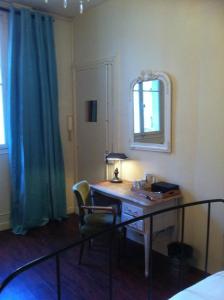 a bedroom with a desk with a lamp and a mirror at A Room In Paris in Paris