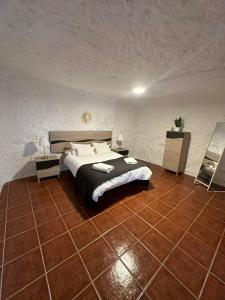 a bedroom with a bed and a tiled floor at Encantadora Casa cueva en Valsequillo in Las Palmas de Gran Canaria