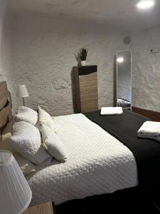 ein Schlafzimmer mit einem großen Bett und einem Spiegel in der Unterkunft Encantadora Casa cueva en Valsequillo in Las Palmas de Gran Canaria