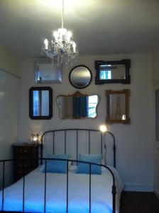 a bedroom with a bed with blue sheets and a chandelier at A Room In Paris in Paris