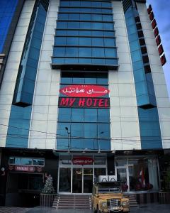 埃爾比勒的住宿－MyHotel Erbil，一辆停在前面的卡车的酒店