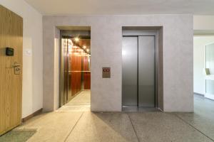 un couloir avec deux ascenseurs dans un bâtiment dans l'établissement Warsaw Concierge Pańska 61, à Varsovie