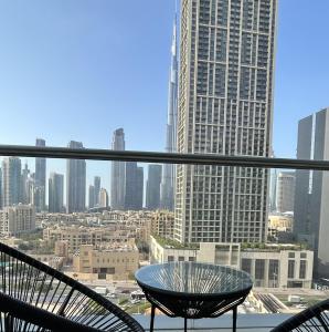 a table and chairs on a balcony in a city at City center with Burj View! in Dubai
