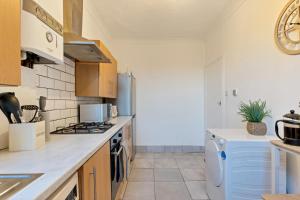 a kitchen with a stove and a refrigerator at Stylish 2 Bed Apartment near Central London in London