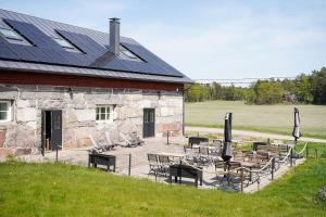 ein Gebäude mit Stühlen und Tischen und einem Solardach in der Unterkunft Hotel Stallbacken Nagu in Nauvo