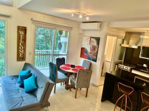 a living room with a blue couch and a table at Duplex Morumbi Luxo in Sao Paulo