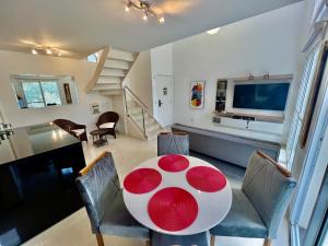 a dining room with a table and chairs and a television at Duplex Morumbi Luxo in Sao Paulo