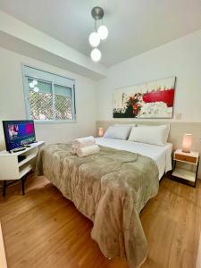 a bedroom with a large bed and a television at Duplex Morumbi Luxo in Sao Paulo