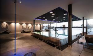 Habitación con mesa de cristal y piscina en Hotel Viertler en Avelengo