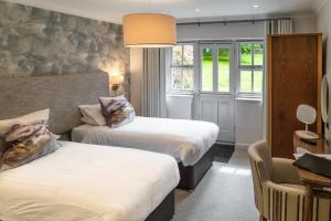 una camera d'albergo con due letti e una sedia di Briery Wood Hotel ad Ambleside