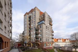 a tall apartment building in the middle of a city at Close to Railway Station Apartment on the 7th Floor in Katowice by Renters in Katowice