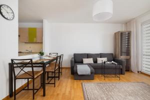 a living room with a couch and a table at Close to Railway Station Apartment on the 7th Floor in Katowice by Renters in Katowice