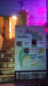 a sign in front of a set of stairs at Funky Buddha Hostel in Mysore