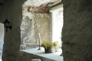 Ein Fenster mit einem Kreuz und einer Pflanze auf der Fensterbank in der Unterkunft Hotel Stallbacken Nagu in Nauvo