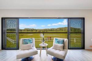 sala de estar con 2 sillas y ventana grande en The Sanctuary - Family Retreat - Noosa Hinterland, en North Arm 56 fotos más
