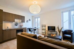 sala de estar con sofá y cocina en One bedroom apartment near tramway & shops en Mouvaux