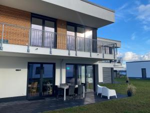 a house with a balcony and a table and chairs at Hangar 19 Seebrise in Schwerin