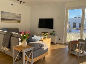 a living room with a couch and a tv at Hangar 19 Seebrise in Schwerin