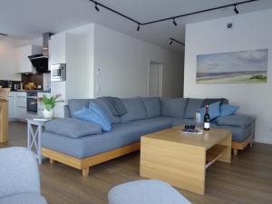 a living room with a blue couch and a table at Hangar 19 Seebrise in Schwerin